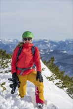 Young woman with camera at the summit of Simetsberg in winter