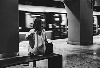 Girl sitting on the bench at metro station