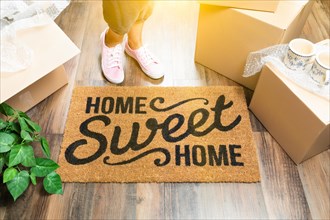 Woman in pink shoes and sweats standing near home sweet home welcome mat