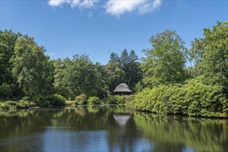 Lake with pavilion in landscape garden and castle park
