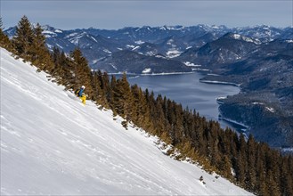 Skier leading down steep slope