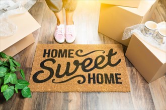 Woman in pink shoes and sweats standing near home sweet home welcome mat