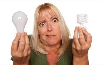Funny faced woman holds energy saving and regular light bulbs isolated on a white background