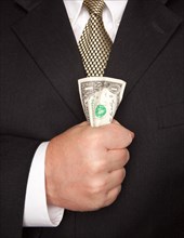 Businessman with coat and tie squeezing dollar bill