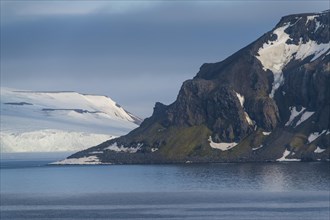 Green cliff in the glacier covered moutains of Franz Josef Land archipelago
