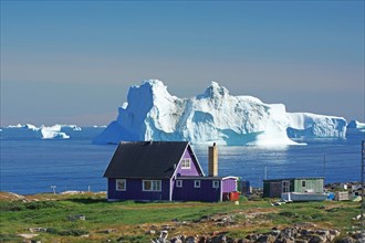 Purple wooden house in front of huge icebergs