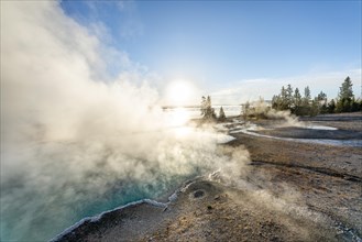 Steaming hot springs with turquoise water in the morning sun