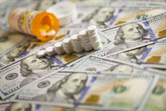 Medicine pills stacked like increasing graph on newly designed U.S. one hundred dollar bills