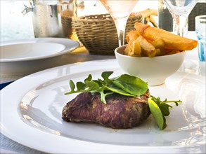 Grilled fillet steak in the evening sun by the sea