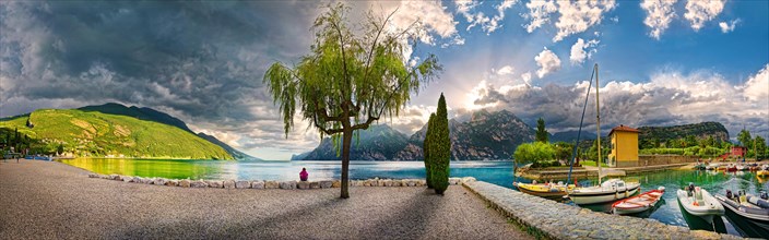 Idyllic Lake Garda north shore with small boat harbour at sunset