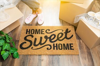 Woman in pink shoes and sweats standing near home sweet home welcome mat