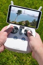 Hands holding drone quadcopter controller with golden gate bridge view on screen