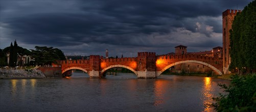 River Adige with the stone bridge Ponte Scaligero at sunset