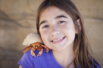 Young pretty girl playing with toy hermit crab