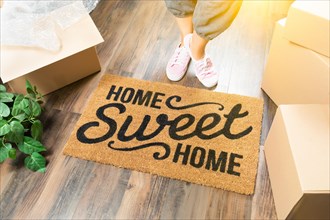 Woman in pink shoes and sweats standing near home sweet home welcome mat