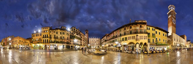 360 panorama of the city square Piazza delle Erbe and former Roman Forum with fountain Fontana Madonna Verona and the medieval tower Torre dei Lamberti in the evening