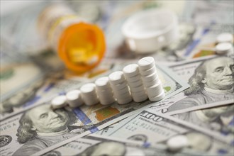 Medicine pills stacked like increasing graph on newly designed U.S. one hundred dollar bills