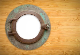 Antique porthole on bamboo wall with white