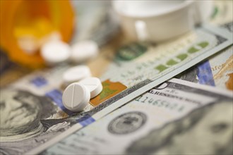 Medicine pills scattered on newly designed U.S. one hundred dollar bills
