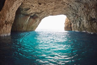 Bright turquoise water at the exit of the collapsed cave Sykia