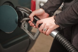 Woman's hands pumping gasoline at the service station