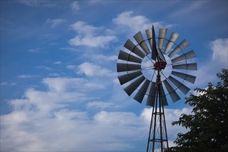 Majestic windmill against a deep blue sky and whispy clouds with room for text