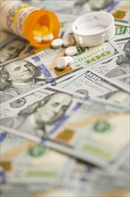 Medicine pills scattered on newly designed U.S. one hundred dollar bills
