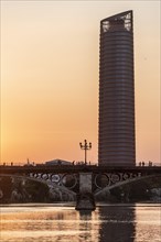 Rio Guadalquivir with bridge Puente de Triana and skyscraper Torre Sevilla