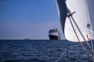 Sailing on the North Sea near Holland with freighter at anchor