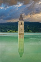 Church tower in the Reschensee with reflection
