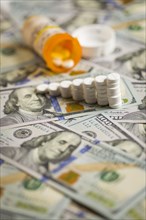 Medicine pills stacked like increasing graph on newly designed U.S. one hundred dollar bills