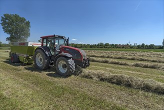Farmer with tractor pressing hay