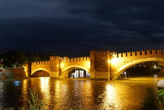 River Adige with the stone bridge Ponte Scaligero at night