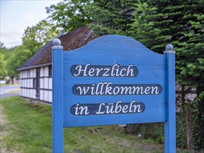 Wooden sign 'Welcome to Luebeln' at the entrance of the Rundlingsdorf Luebeln