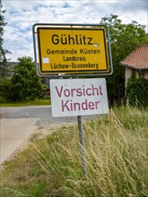 Place name sign and 'Caution children' sign at the entrance to the Rundlingsdorf Guehlitz. The village is one of the 19 Rundling villages that have applied to become a UNESCO World Heritage Site. Gueh...