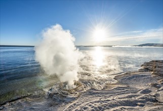 Steaming fumarole at the lake with morning sun