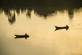 Fishermen in their canoes fishing at sunset on the Nile at Jinja source of the Nile