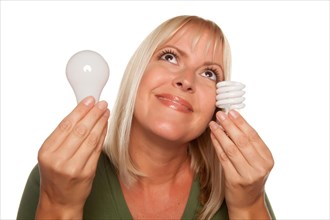 Smiling woman holds energy saving and regular light bulbs isolated on a white background