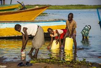 Children filling water in canisters at Lake Albert