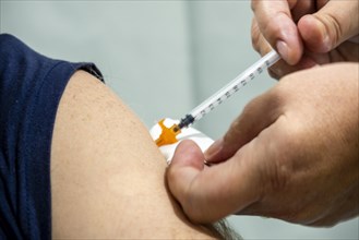 Close up of arm of a man getting shot of Covid 19 vaccine