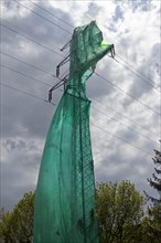 High voltage pylon covered with a tarpaulin due to maintenance work