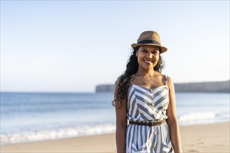 Portrait of a beautiful young woman on the beach by sunset in Algarve
