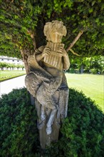 Statue under a tree in the Baroque gardens in the Wuerzburg Residence
