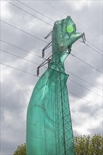 High voltage pylon covered with a tarpaulin due to maintenance work