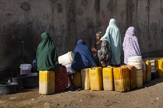 Women at a water well collecting water