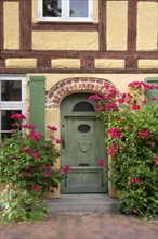 Roses blooming in front of a half-timbered house
