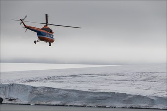 Helicopter flying over the giant icefield of Alexandra Land