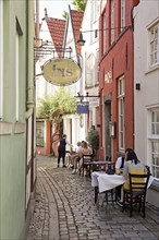 Outdoor restaurant in a small alley in the old town in the Schnoor or Schnoorviertel