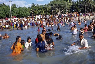 Devotees taking a dip in the holy waters of the Agni Theertham on new moon day