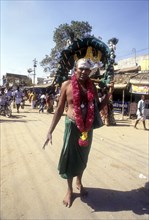 A sadhu carrying Kavadi on his shoulder to Palani on Thai Poosam day
